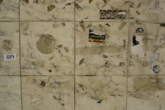 Close-up of layered stickers showing patina and overlapping messages